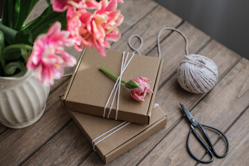 Kraft gift boxes decorated with flowers. Preparation of gifts for mother's day, birthday, women's holiday. Gift wrapping idea