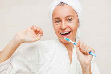 portrait of gorgeous happy middle age woman looking at mirror touching her skin