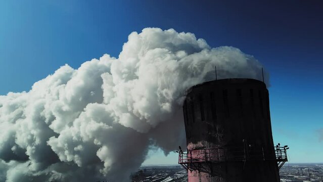The consequence of burning coal. Industrial pipe for the emission of hydrocarbons. A cloud of steam against a blue sky.