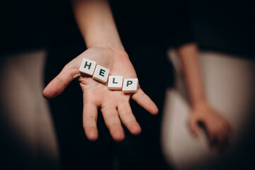 Girl asking for help. Girl stretches out her hands with the word help in the palms