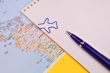 Airplane clip, notebook and pen on map background, copy space, idea concept for fly trip travel plan on holiday.