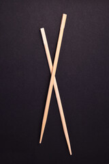 Wooden pairs of chopsticks on black background
