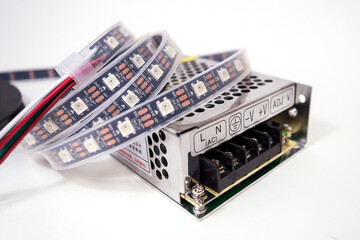 Plastic coil with a led light-emitting diode tape in a silicone shell with a transformer on a white...