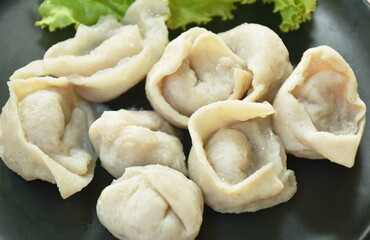 steamed fish dumpling with lettuce on plate dipping spicy and sour sauce