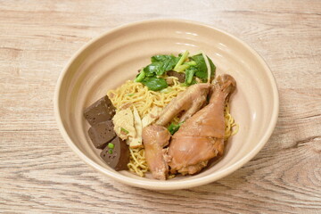 boiled dry egg yellow noodles topping braised chicken leg and foot dressing sweet black soybean sauce on bowl