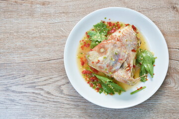 steamed mango fish head with chili and lemon dressings celery on plate