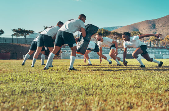 Giving their all at rugby practice. Shot of a group of rugby players training with tackle bags on the field.