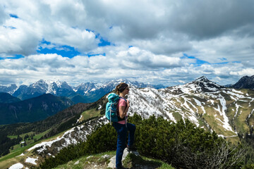 Fototapeta na wymiar Hiker woman with backpack at summit of Hahnkogel (Klek) with scenic view on mountain peaks in Karawanks and Julian Alps, Carinthia, Austria. Border with Slovenia. Triglav National Park. Goal seeking