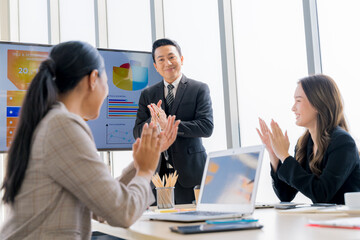 Cheerful young Asian businessman Excited and glad applauded. About successful startup projects Happy Asian colleagues celebrating business success in office meeting.