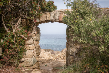 A stone doorway with a view through to the Mediterranean sea at Davia on the west coast of Corsica