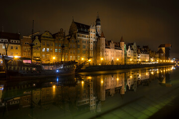 Naklejka na ściany i meble Nightshot of St Mary's Gate and Other Houses in the Old Town of Gdansk Reflecting in Motlawa River, Poland