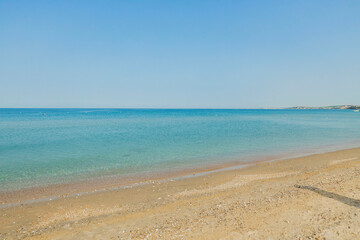 Fototapeta na wymiar Beautiful view of white sand beach and calm turquoise Mediterranean waters. Greece.