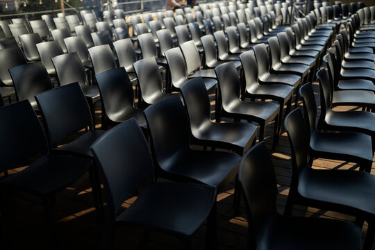 Many Black Chairs in a Row. evocative series of chairs. rows of chairs, empty seats - chair row