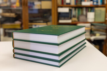 a pile of PhD theses of green cover, office or library background
