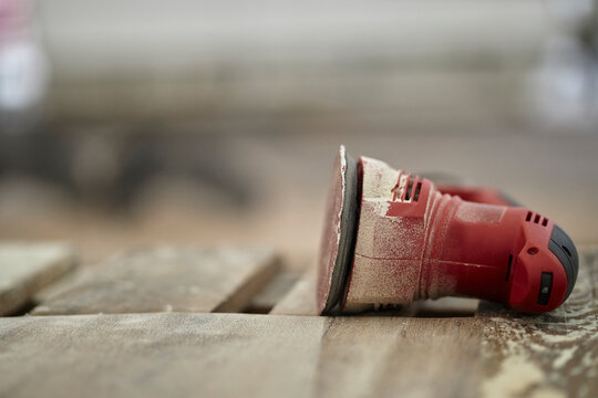 orbital sander for sanding and polishing wood close-up. orbital red sander for sanding and polishing wood close-up