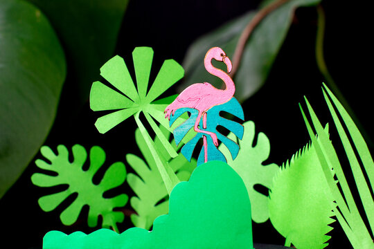 Wooden flamingo among paper tropics