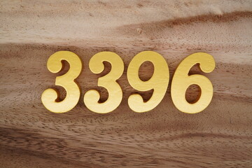 Golden Arabic numerals on a real brown and white wooden floor number 3396