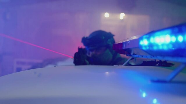 4k Special Force or police man holding weapon near car flasher or roof . Close up view of Police surrounding . Military police or lasertag concept . Shot on ARRI Alexa cinematic camera in slow motion