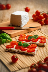 Quartirolo lombardo su pane wasa, pomodorini, basilico, sale e pepe