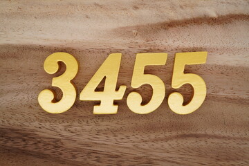 Golden Arabic numerals on a real brown and white wooden floor number 3455