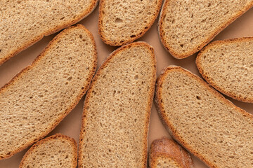 Slices of bread on a brown background. Top view.