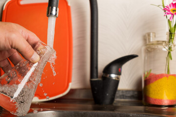 A man pours tap water into a glass flask.