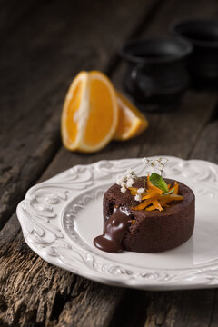 Chocolate fountain, orange cupcake. Photo of food on a dark background