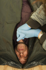 Fototapeta premium Crime scene investigation - dead man placed in body bag