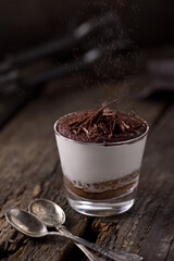 Sweet dessert chocolate panna cotta in a glass. Photo of food on a light background