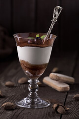 Sweet dessert chocolate panna cotta in a glass of blueberries. Photo of food on a dark background