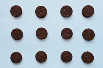 Composition of chocolate sandwich cookies on light blue background
