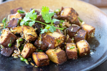 Stir-fried black tofu with chili, salt, garlic and pepper. Authentic the rare black tofu found only in Ratchaburi, Photharam Village, Thailand. Balance salty and sweet stew with sweet herbal gravy.