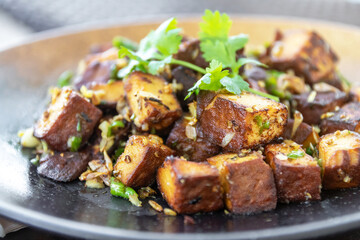 Stir-fried black tofu with chili, salt, garlic and pepper. Authentic the rare black tofu found only in Ratchaburi, Photharam Village, Thailand. Balance salty and sweet stew with sweet herbal gravy.