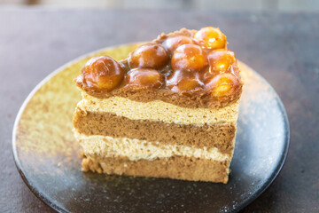Slice of macadamia cake, coffee layer cake with caramel macadamia nut topping on plate.
