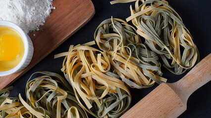 Uncooked Italian homemade egg pasta with spinach placed side by side