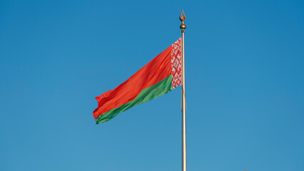 State flags of the Republic of Belarus are waving in the wind on blue sky background. Space for text.