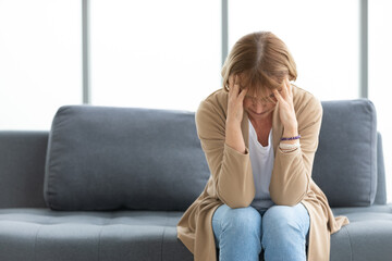 senior woman have a headache on a sofa