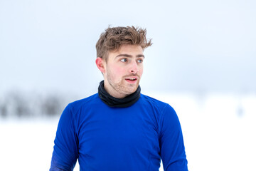 Portrait eines gut aussehenden jungen Sportlers in einer kalten, weißen schneebedeckten...