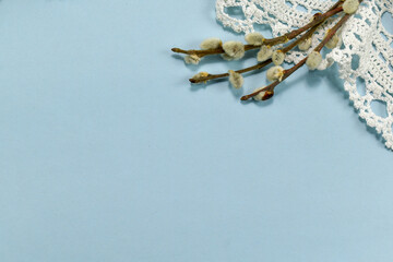 Easter composition.  willow branch, crocheted white napkin on a blue background. Top view. Space for text