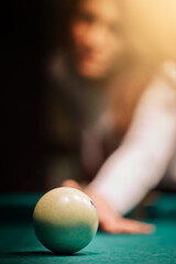 Blurry silhouette of a girl playing billiards