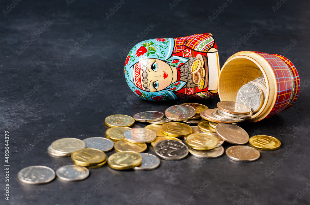 Wall mural Traditional Russian toy matryoshka and money. Black concrete background.