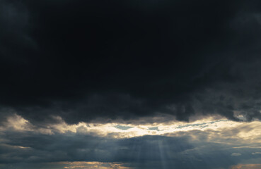 Fototapeta na wymiar beautiful dramatic sky and sunlight, dark silhouette of clouds as background