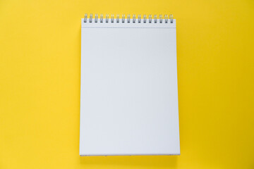 White notepad for notes on a yellow background.