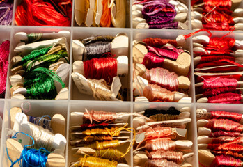 Group of threads of varied colors in small skeins of paper, inside a plastic organizer. Copy space. Technological detox.