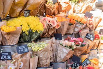 Flower business. Flowers are white in kraft paper standing on the counter.
