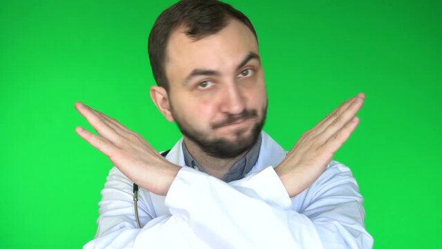 Medical doctor man looking at camera and said No by crossing his arms. Green screen background