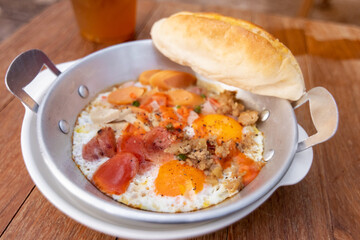 Eggs are cooked in a little pan served in, and topped with sweet sausage and pork stick. Pan Eggs or 