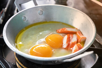 Eggs are cooked in a little pan served in, and topped with sweet sausage and pork stick. Pan Eggs or 