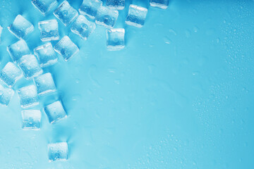 Lots of ice cubes with water drops scattered on a blue background