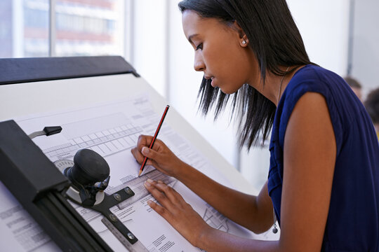 This is what she does best. Cropped shot of an attractive female architect working at a drawing board.